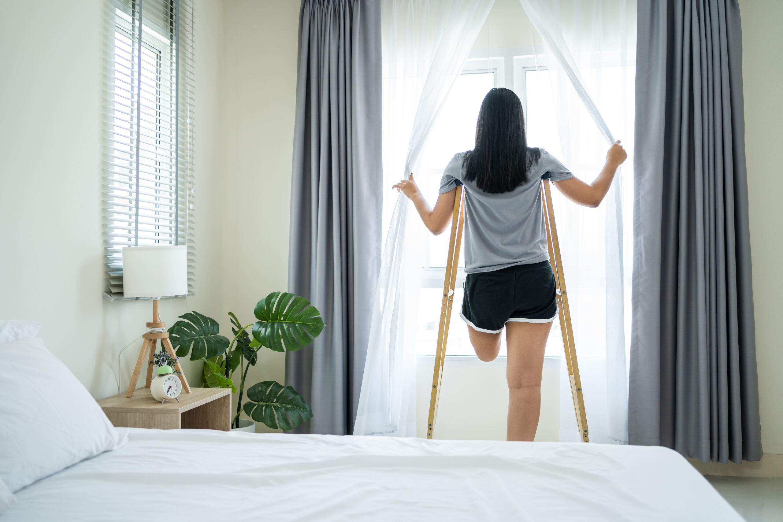 Asian young amputee leg woman wake up and stretching body in morning. Asian young amputee leg woman wake up and stretching body in morning. Attractive female having no leg feel happy and relax, getting up from sleep on bed in bedroom at home. Leisure lifestyles in house