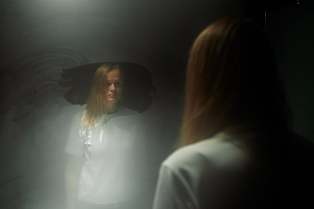woman reflected in foggy mirror