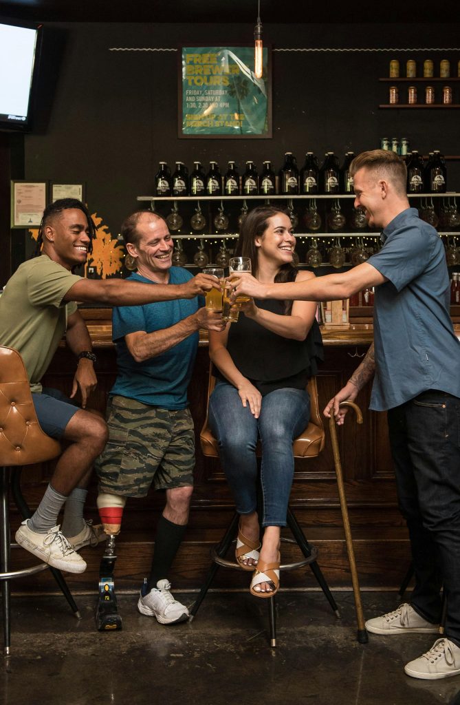 A joyful group of friends celebrating with drinks in a welcoming bar, showcasing diversity and inclusion.